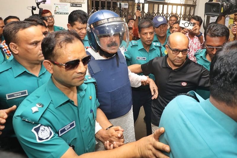 Police escort former shipping minister Shajahan Khan to a court in Dhaka on 6 September 2024.